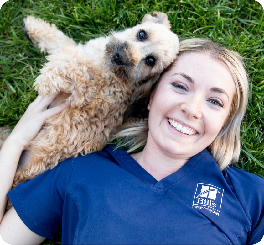 women lying on the grass with dog