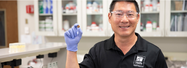 Hill's Pet Researcher holding Hill's Pet food kibble in his hand
